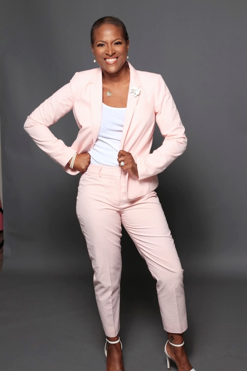 LaWanda Crawford standing in a pink suit against a gray studio backdrop